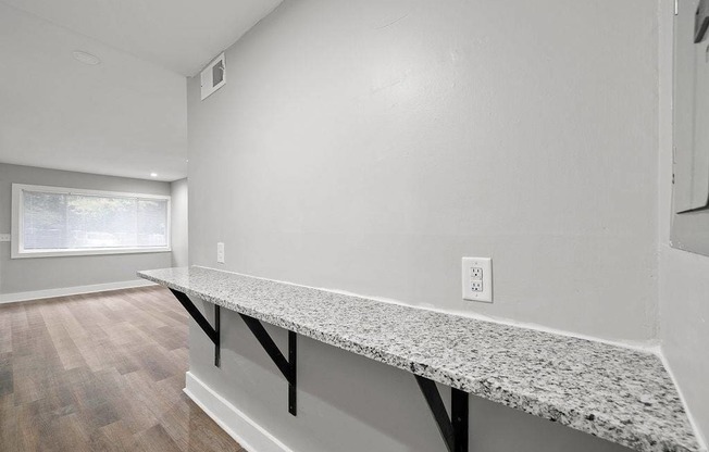 A kitchen counter with a window and a light switch.