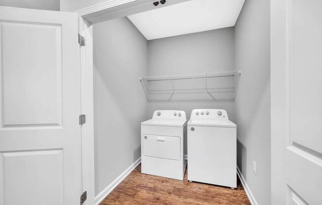 the laundry room of a home with two washes and a dryer