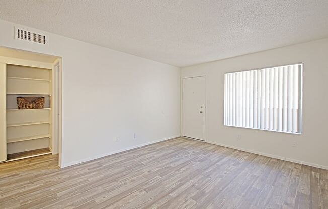 a bedroom with hardwood floors and a large window