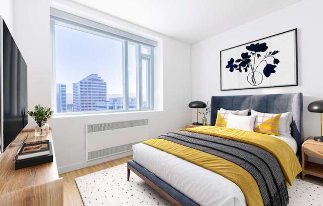 A modern bedroom with a large bed and a city view through the window.