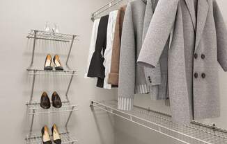 A closet with a coat hanging on a rod and a shelf with shoes.