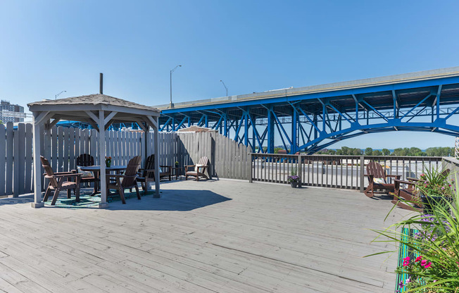 the deck has a picnic table and a gazebo and a blue bridge