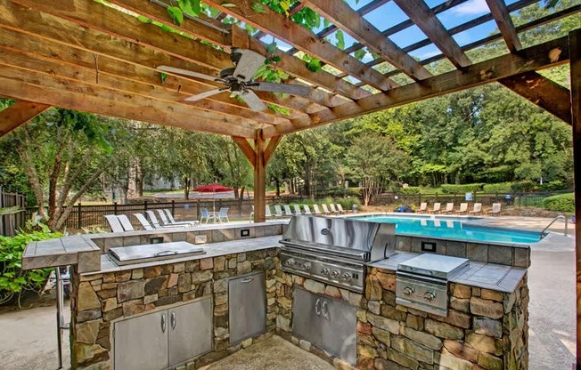 A patio with a grill and a pool table. at Mill House at East Cobb, Marietta, GA 30067
