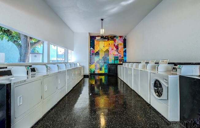 A laundromat with a row of washers and dryers.