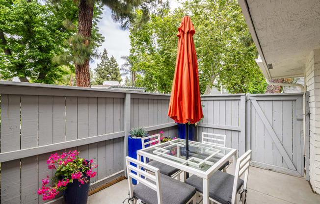 a patio with a table and chairs and an umbrella