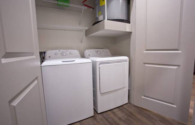 a washer and dryer in a closet with white doors