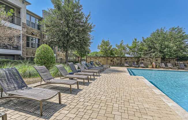 a swimming pool with chaise lounge chairs next to a building at Discovery at Craig Ranch, McKinney, Texas
