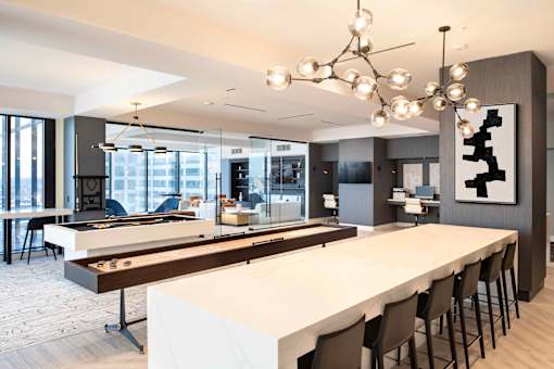 a communal table with a shuffleboard and foosball table at 220 Meridian, Indianapolis, IN 46204