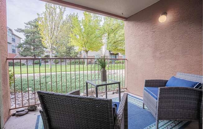 a patio with chairs and a table on a balcony