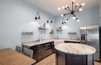 A modern kitchen with a central island and a wooden table.