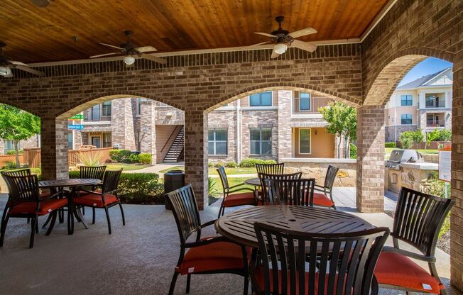 an outdoor patio with tables and chairs