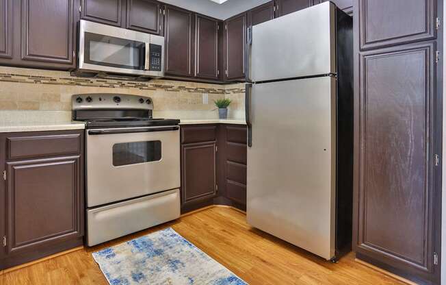 A1 kitchen with wood cabinets and stainless steel appliances at The Inverness Apartments in Houston, TX