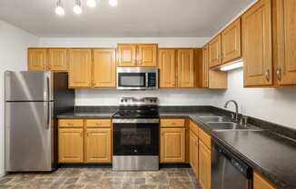 a kitchen with wooden cabinets and stainless steel appliances