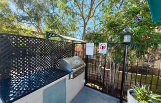 A black and white grill with a no smoking sign on a fence.