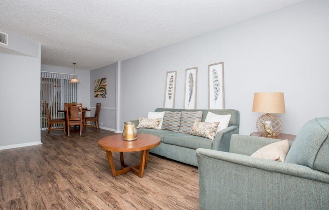 a living room and dining room with couches and a table