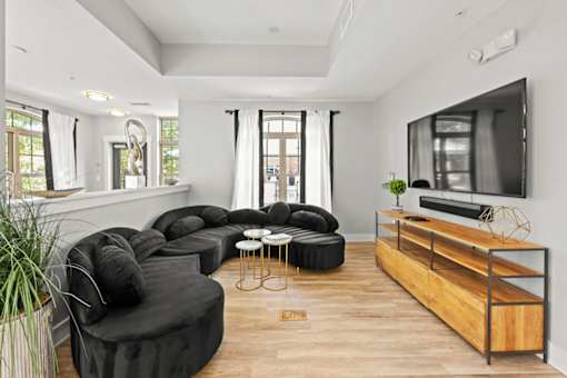 A modern living room with black furniture and a wooden entertainment center.