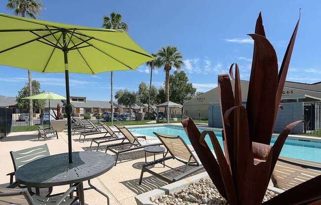 a swimming pool with tables and umbrellas