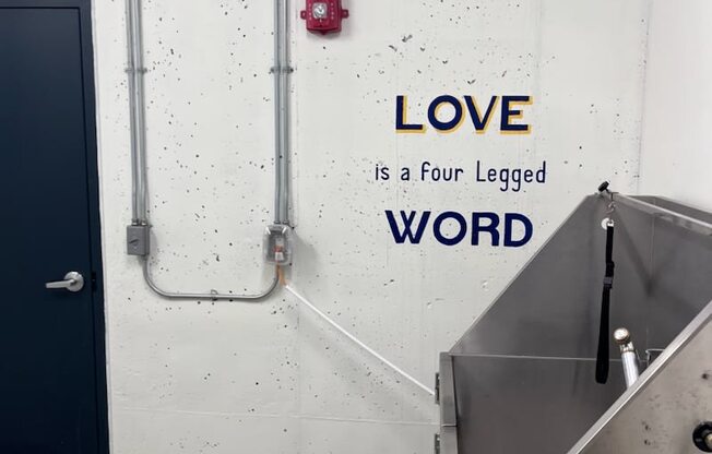 A wall with the words love is a four legged word and the dog wash station at WH Flats apartments in Lincoln, NE