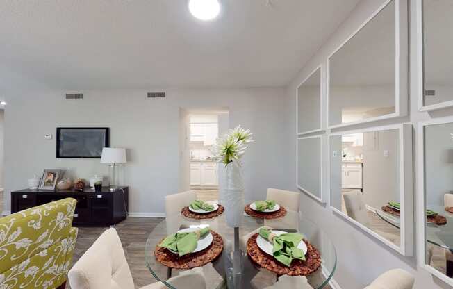 a living room with white walls and a glass table with three plates of food on it