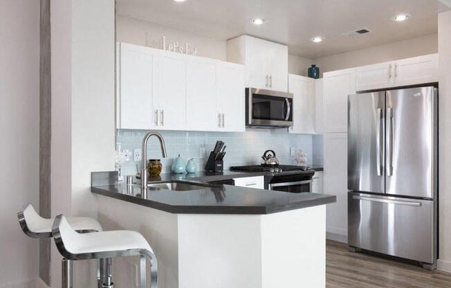 Kitchen with stainless steel appliances and bar seating