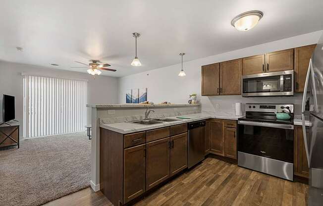 a kitchen with wooden cabinets and stainless steel appliances at Red Rock Apartments, Rapid City, SD