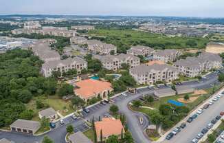 A bird's eye view of a residential area with houses and a parking lot.