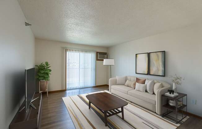 Fargo, ND Parkside Apartments. A living room with a couch, coffee table, tv, and a glass sliding door.