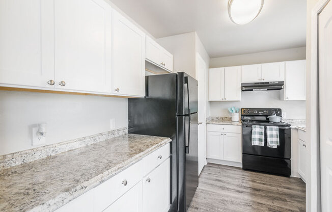 Kitchen with white cabinets and black appliances_Rolling Hills Apartments