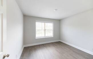 an empty room with white walls and a window