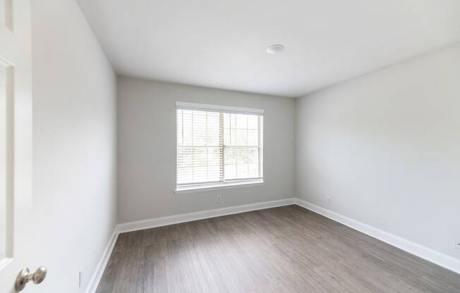 an empty room with white walls and a window