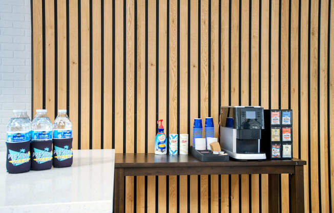 a counter with a coffee machine and water bottles at Presidio Palms Apartments, Tucson, Arizona