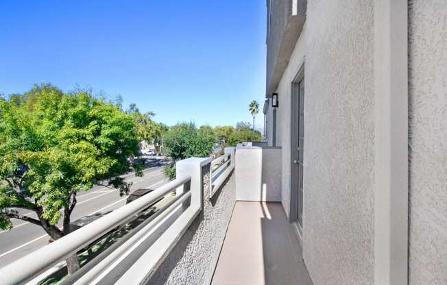 the view from the balcony of a large apartment building overlooking a city street