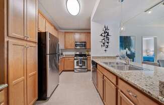 A kitchen with wooden cabinets and granite countertops.