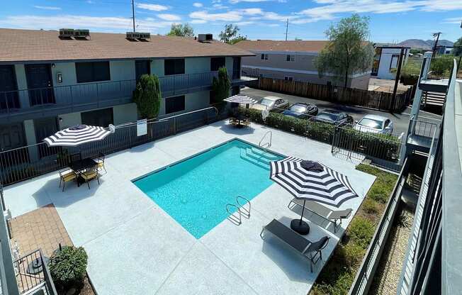 an aerial view of a swimming pool and patio with umbrellas