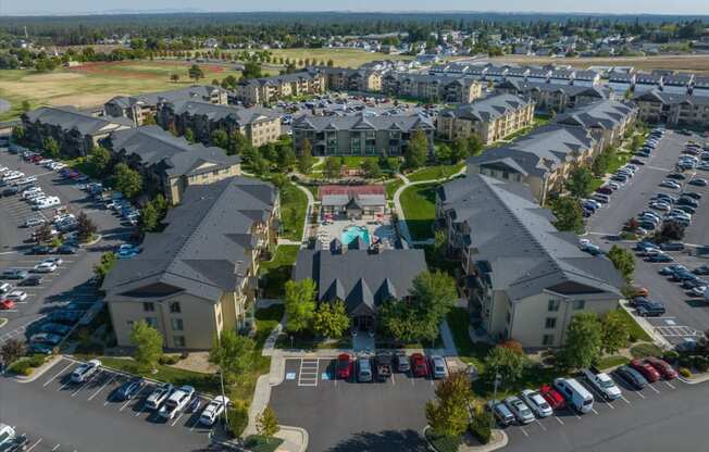 an aerial view of an apartment complex with cars parked in a parking lot