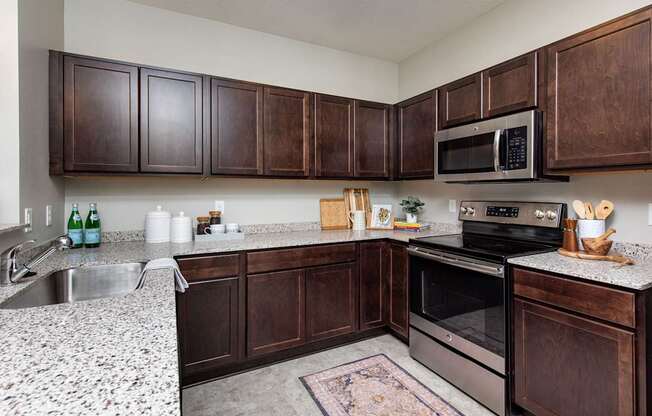 modern kitchen with stainless steel appliances and wood cabinets at Lake Shore Apartments, Ankeny, IA