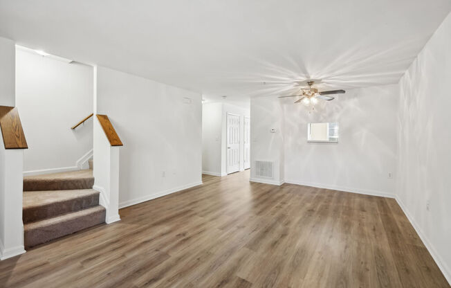 a living room with hardwood floors and a ceiling fan