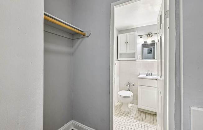 A bathroom with a toilet, sink, and a mirror.