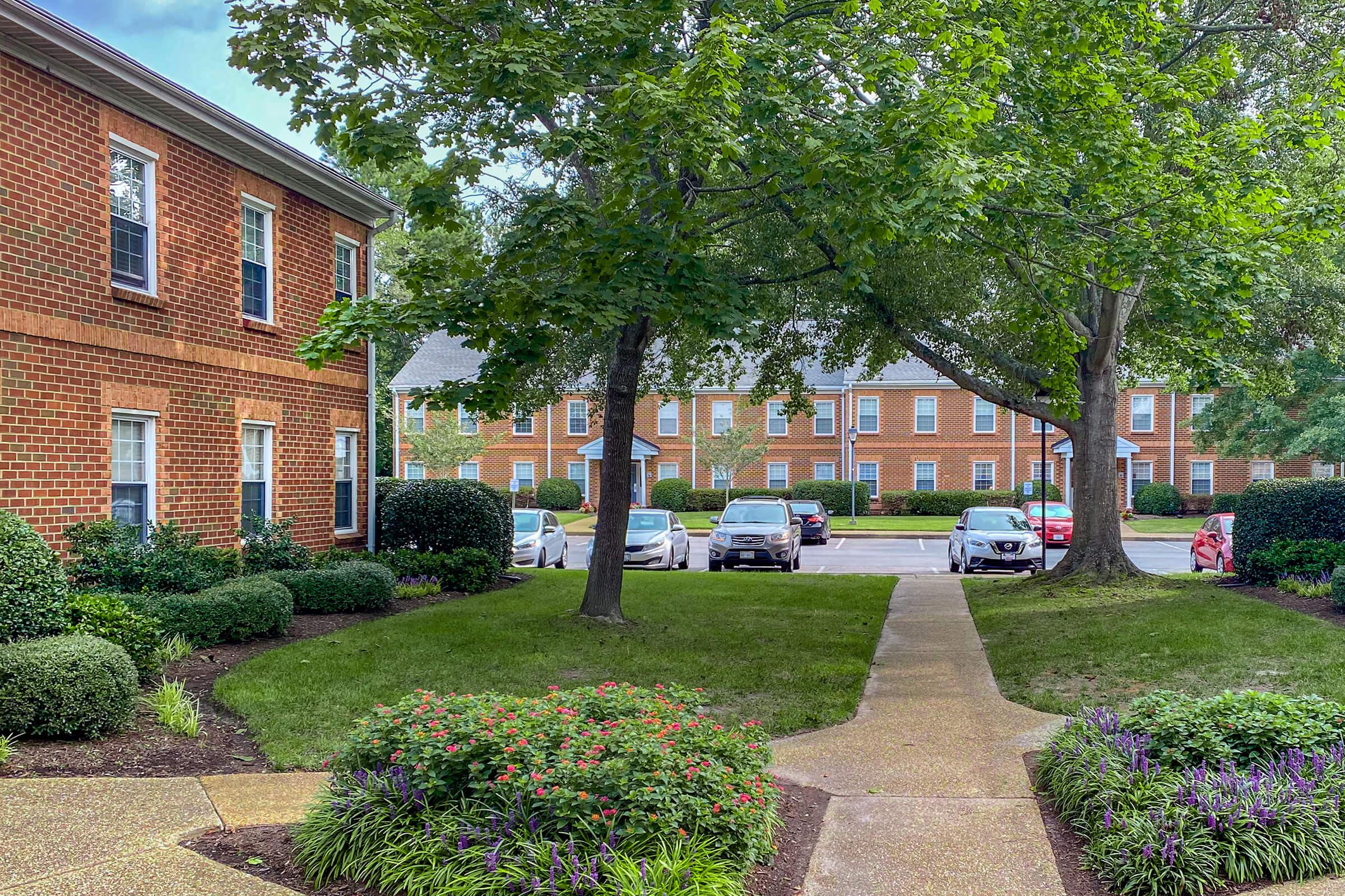 a large brick building with grass in front of a house