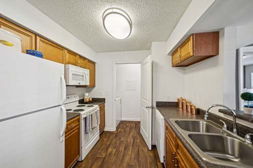 A kitchen with a white fridge and wooden cabinets.