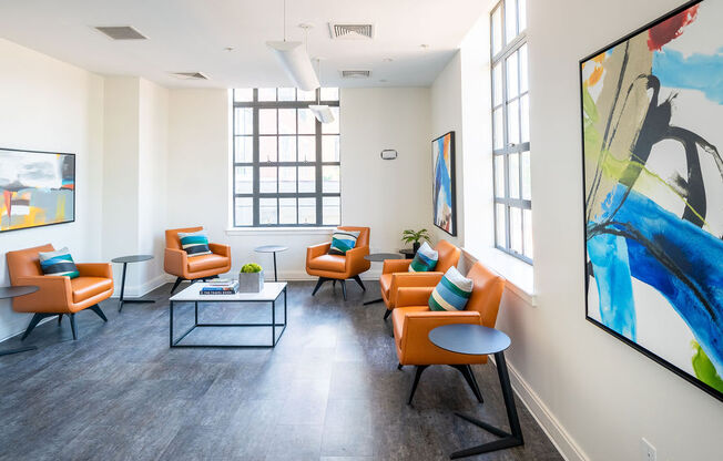 a living room with orange chairs and a table