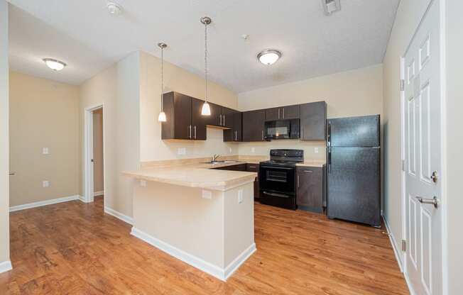 a kitchen with a large island and a black refrigerator