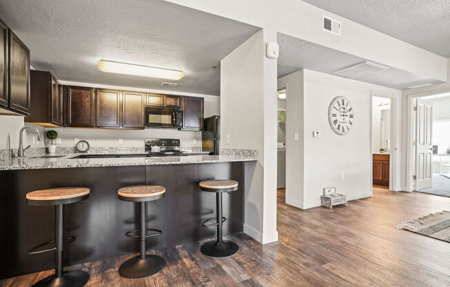 a kitchen with a bar with three stools