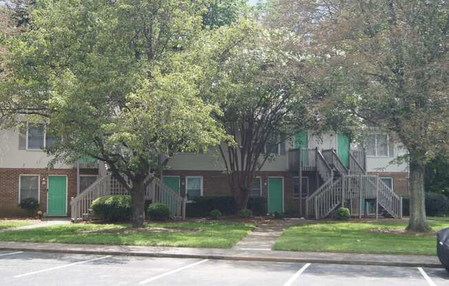 an apartment building with stairs and green doors
