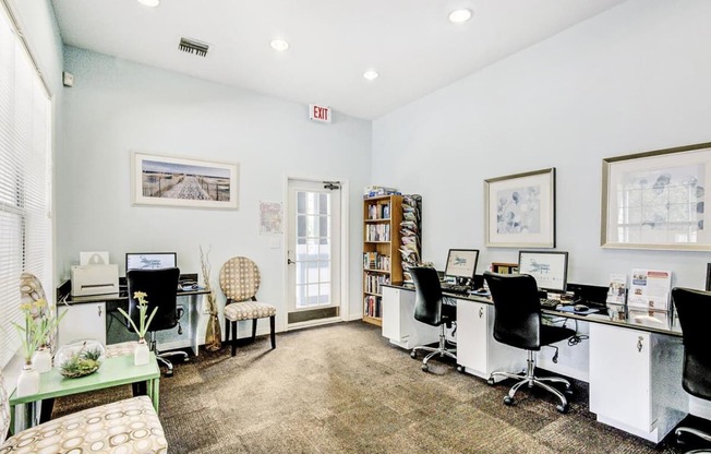 Business Center with Computers on Desk Counters with Office Chairs Next to Fully Stocked Bookshelf