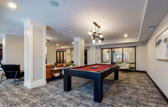 a spacious living room with a billiard table in the center of the room
