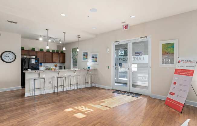 a common room with a kitchen and a door to the lobby of a building