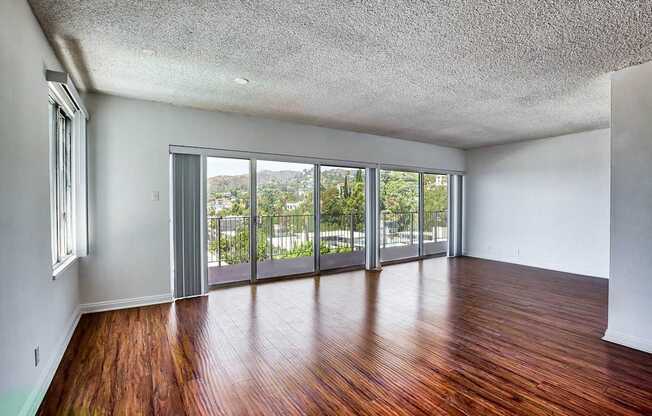 A room with wooden floors and sliding glass doors.at Hollywood Ardmore, Los Angeles, CA 90028
