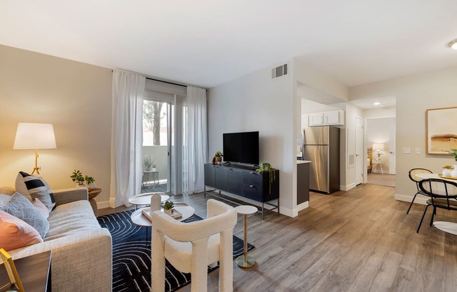a living room with a couch and a tv at Paisley and Pointe Apartments, Las Vegas
