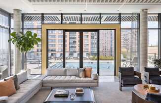 a room with couches and chairs and a view of a building at The Lively, Jersey City New Jersey